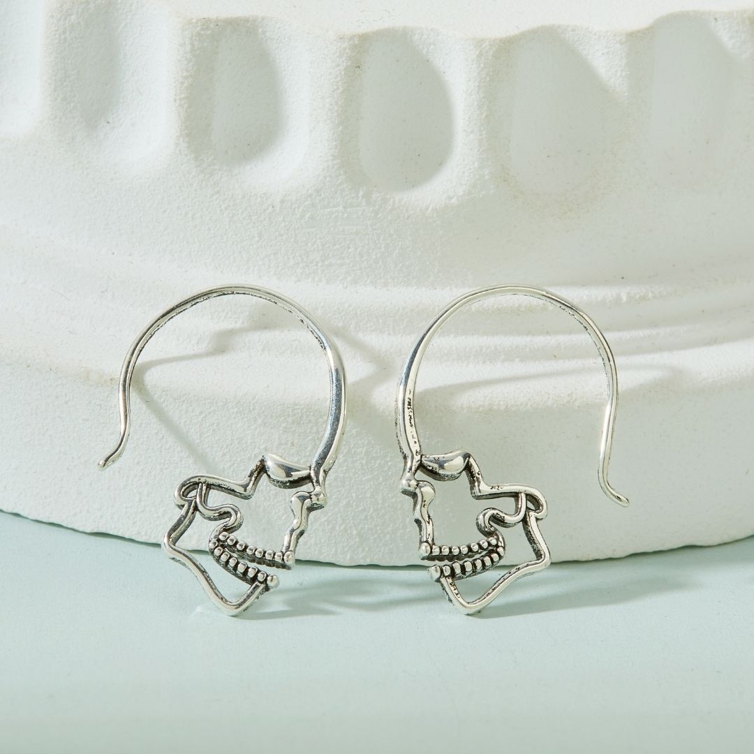 PAIRE DE BOUCLES D'OREILLES EN ARGENT EN FORME DE CRÂNE